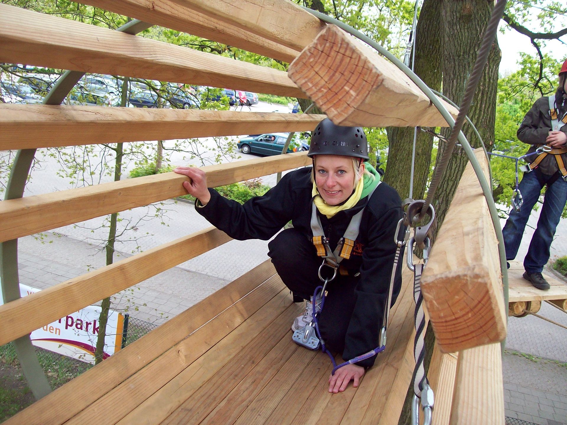 Eine Frau mit Helm sitzt auf einer Holzbank