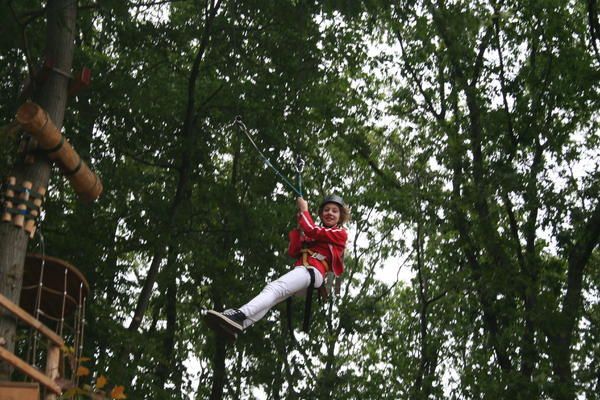 Eine Person fliegt auf einem Hochseilgarten durch die Luft