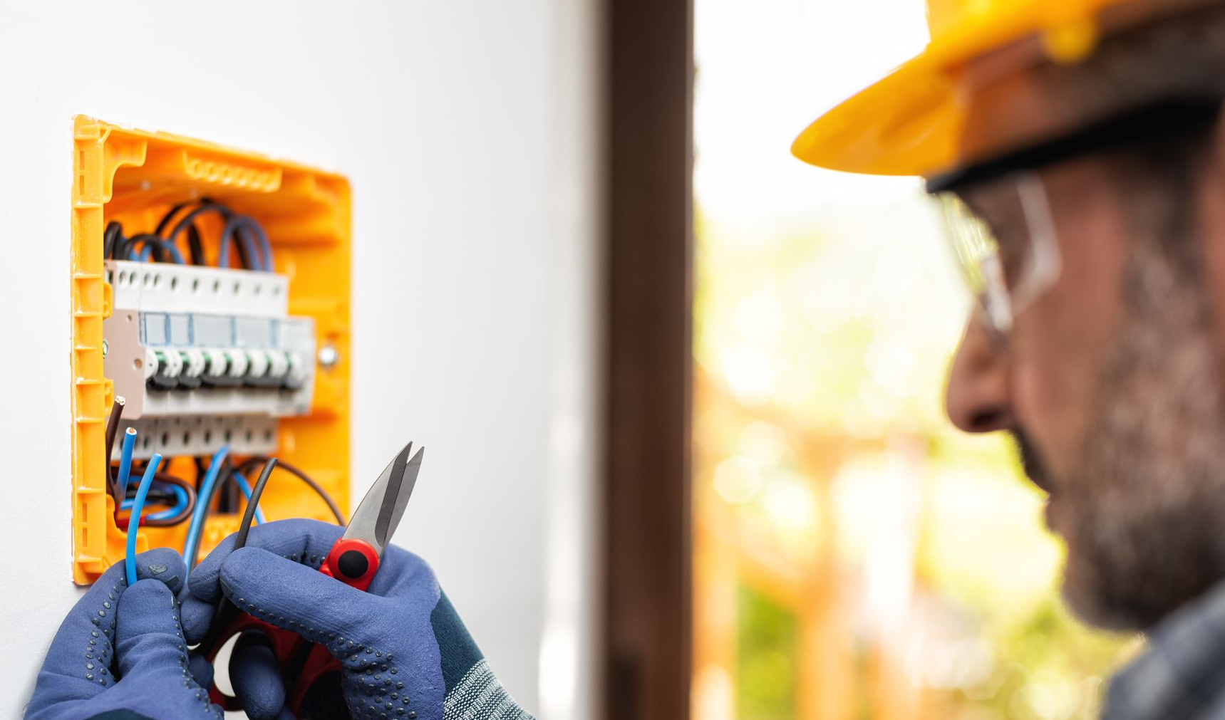 Un électricien avec un casque jaune