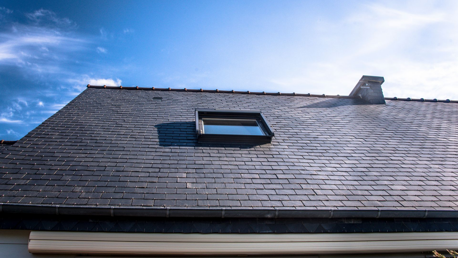 Toit en ardoise avec puits de lumière.