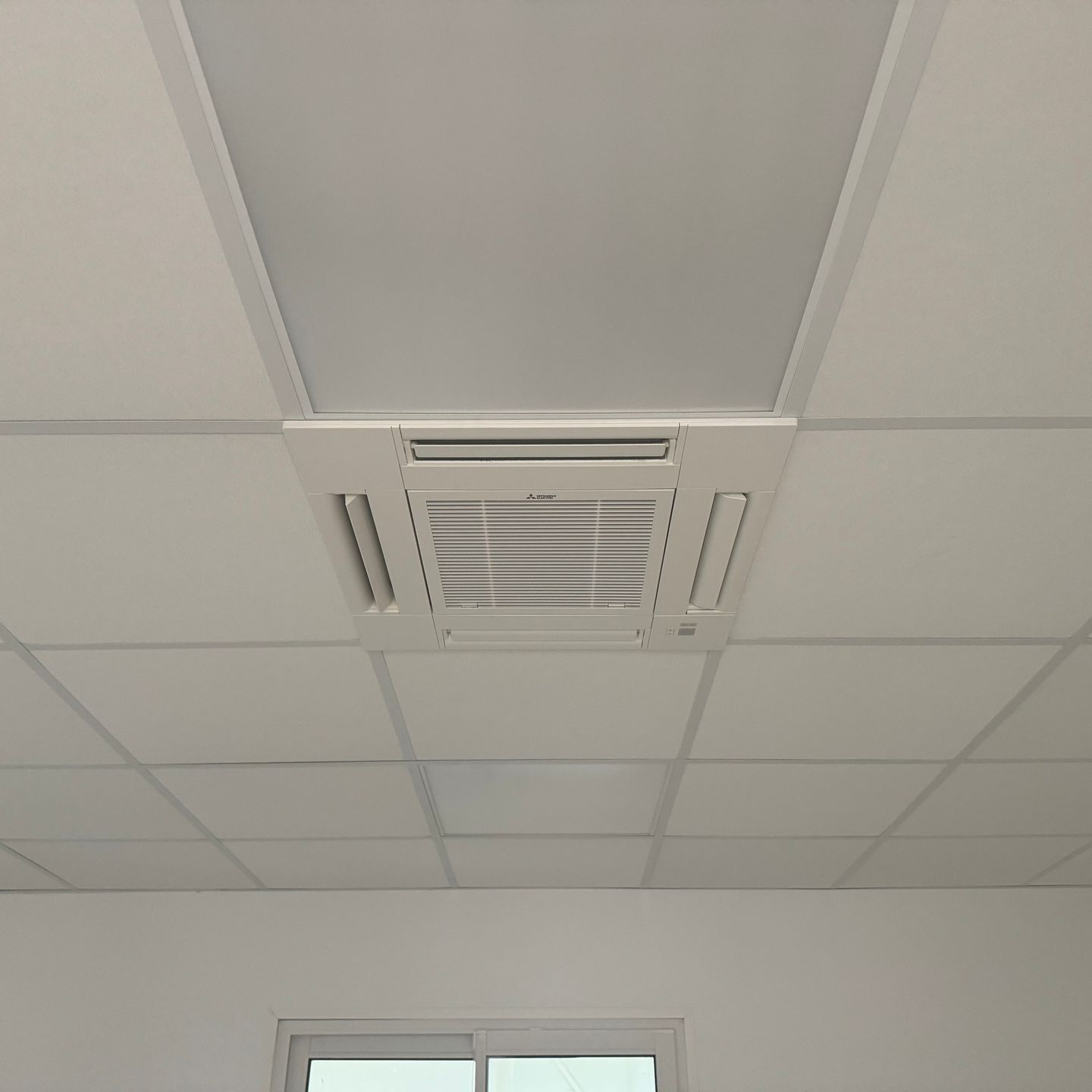 Grille de climatisation gainable blanche intégrée dans un faux plafond