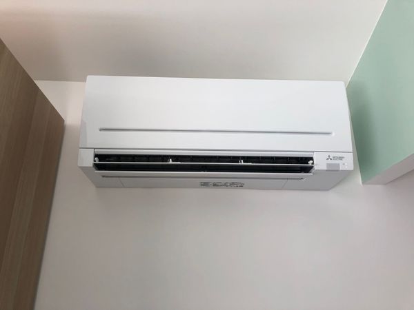 Un climatiseur mural blanc sur un mur blanc