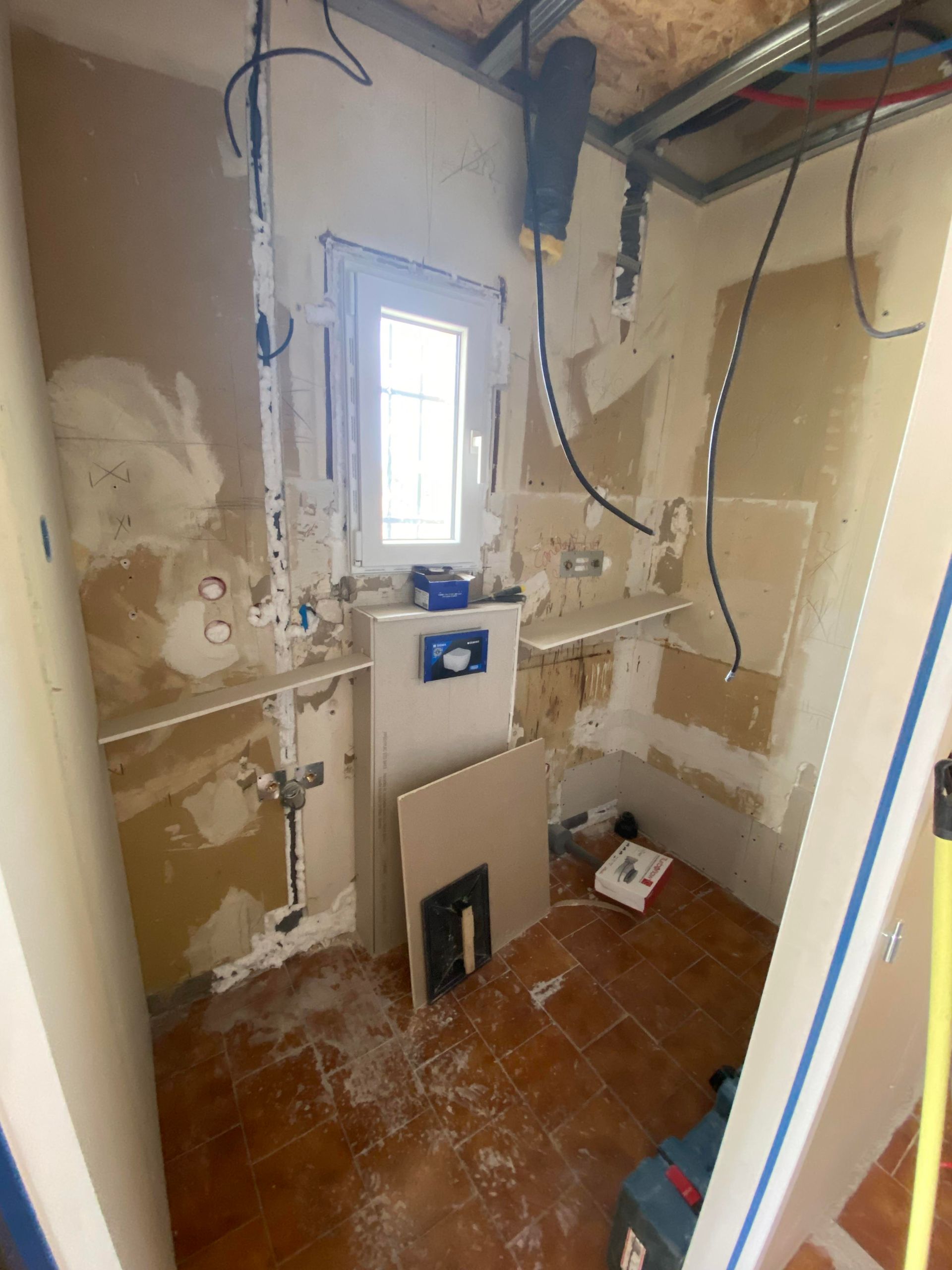 Travaux de rénovation d'une salle de bains, fils électriques tombant du plafond