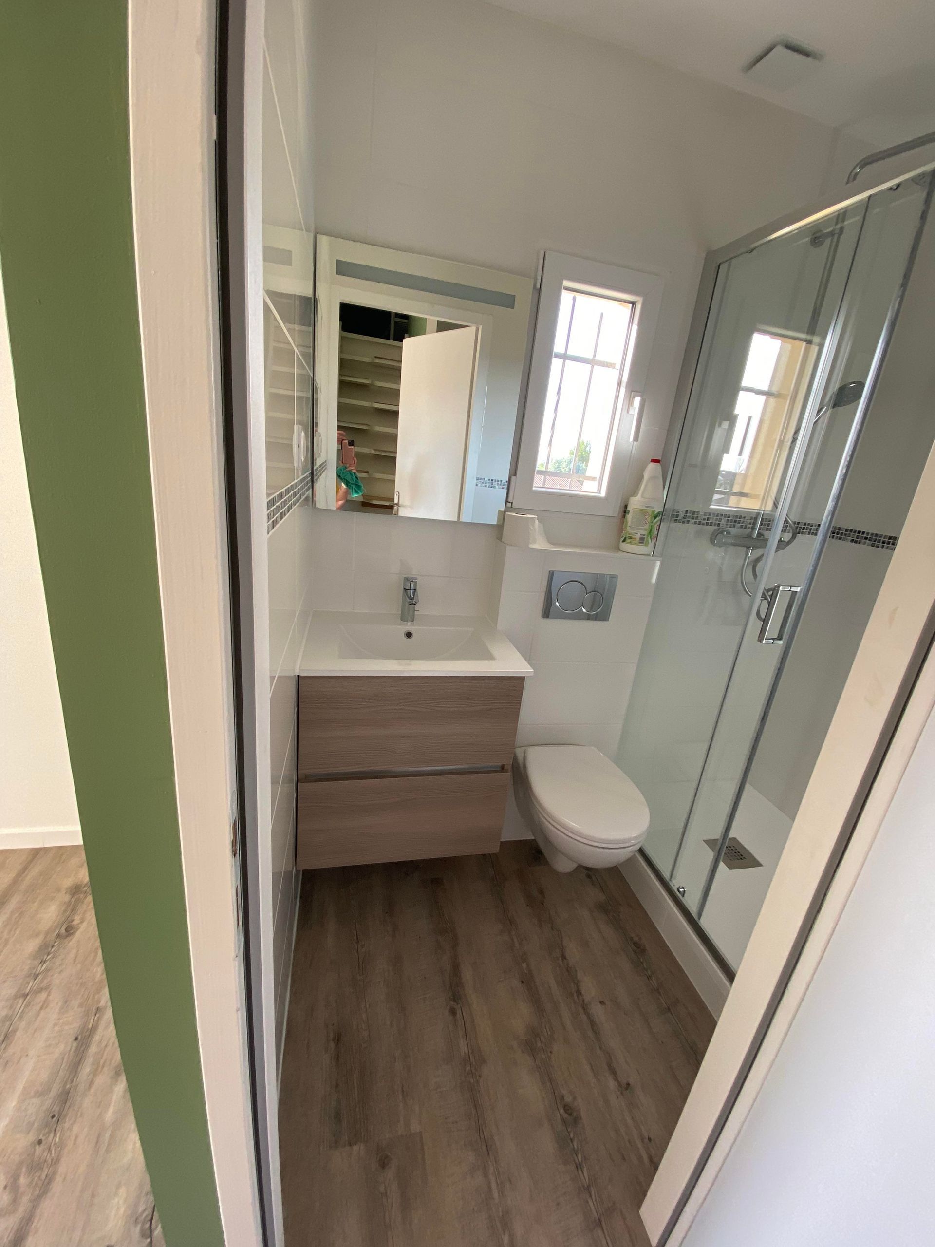 Salle de bains après travaux de rénovation avec douche, meuble vasque et toilettes