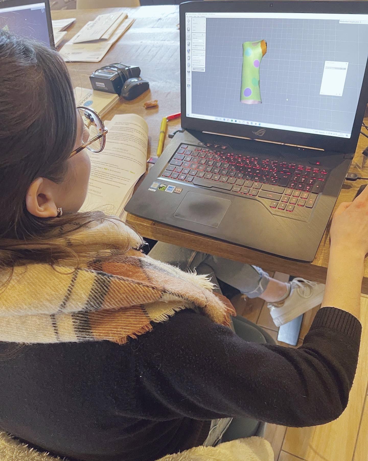 Une personne regarde l'écran de son ordinateur affichant un modèle d'orthèse de poignet en 3D