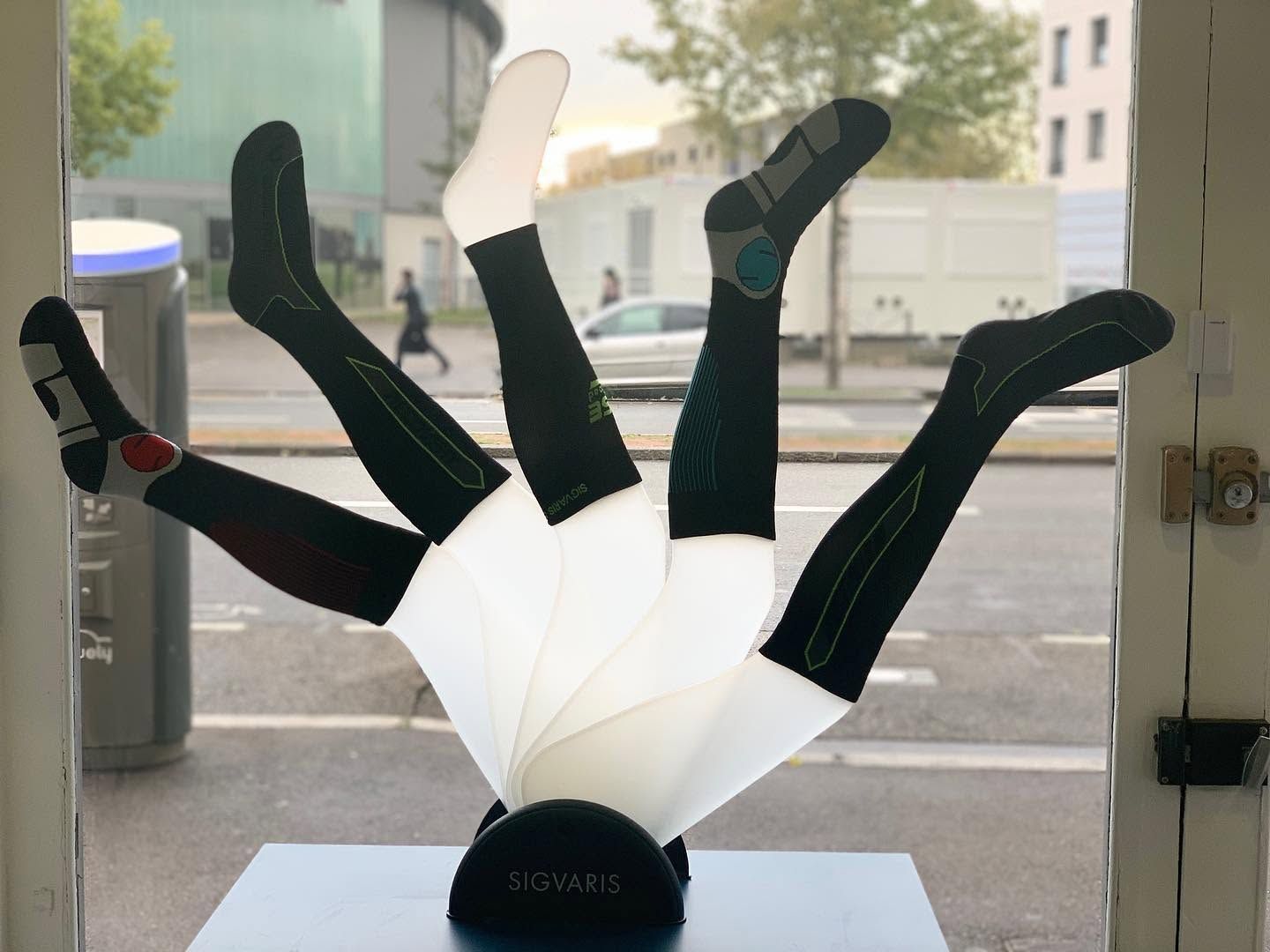 Chaussettes de compression présentées en forme d'éventail sur un rebord de fenêtre