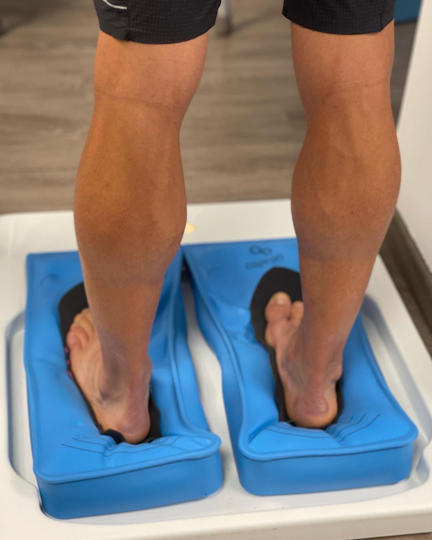 Personne debout sur les coussins à dépression de la machine de thermoformage, les pieds tournés vers l'intérieur, vue de dos.