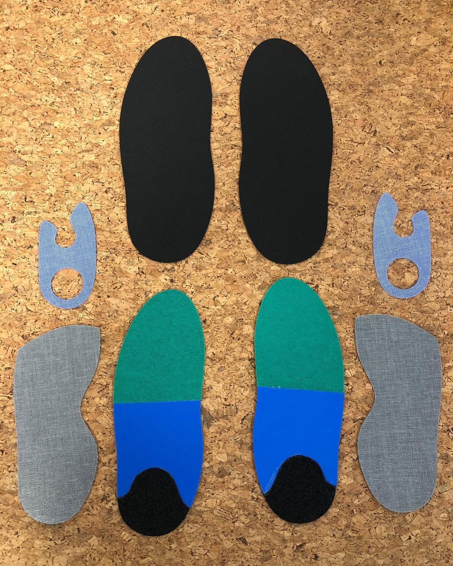 Semelles thermoformées et morceaux découpés de couleurs assorties, disposés sur un fond en liège.