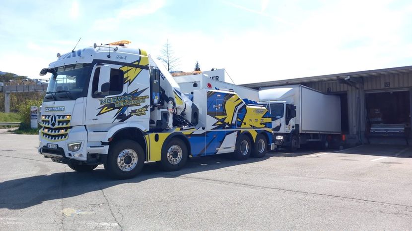 Camion qui remorque un bus dans la neige