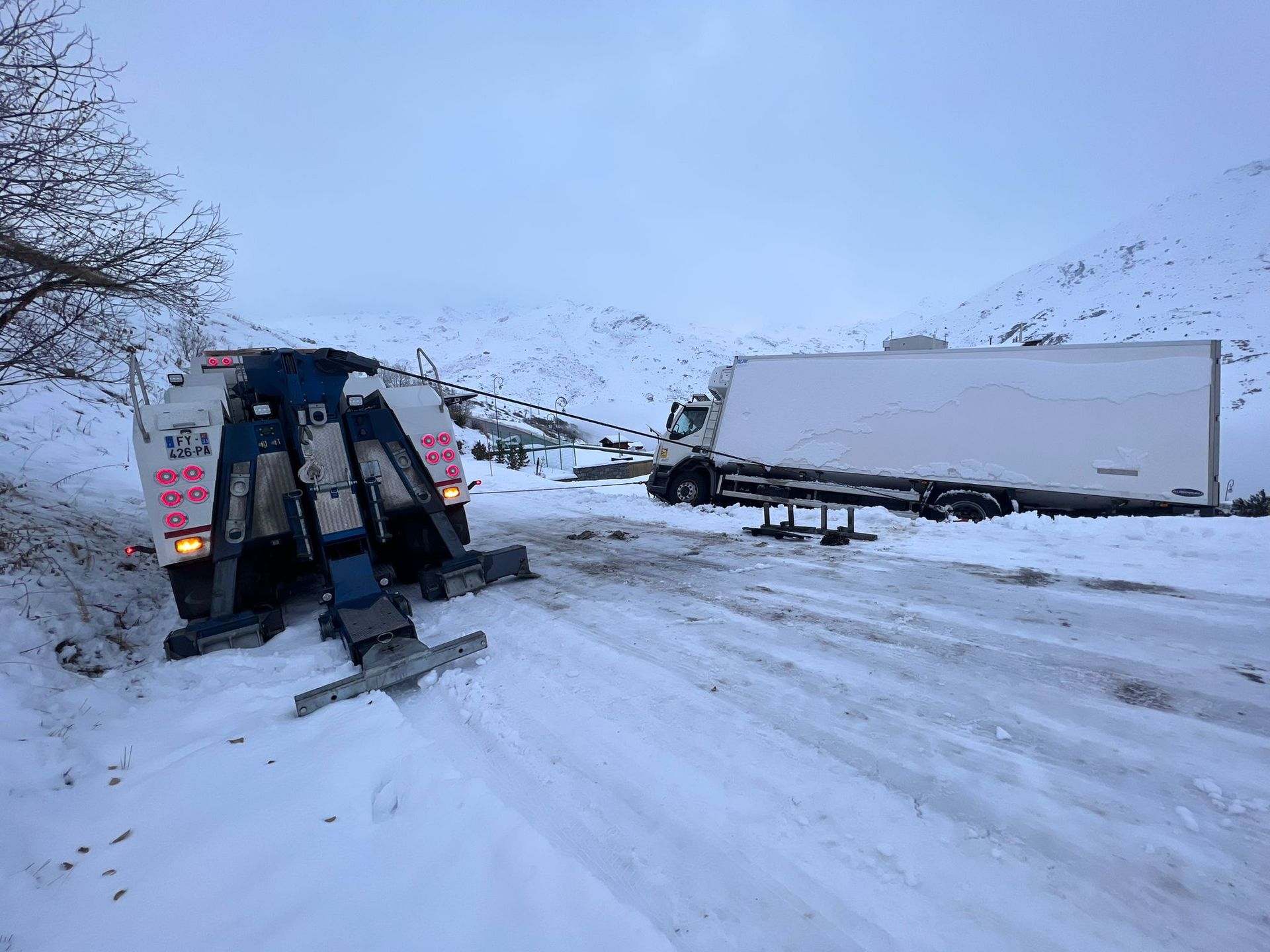 Véhicule de dépannage remorquant camion bleu