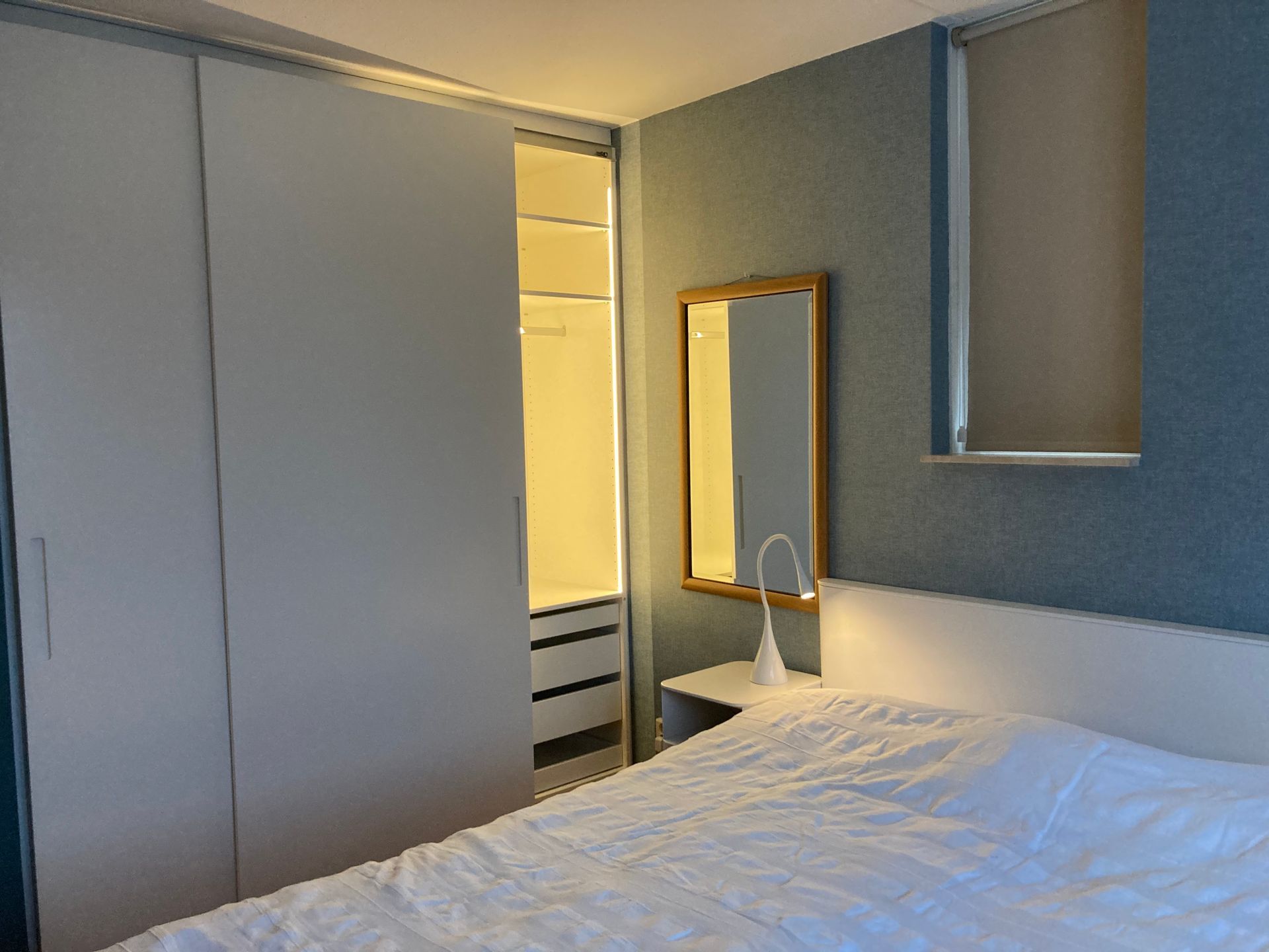 Tischlerei Schlichtenbrede GmbH - Ein Schlafzimmer mit Bett, Spiegel und Schrank