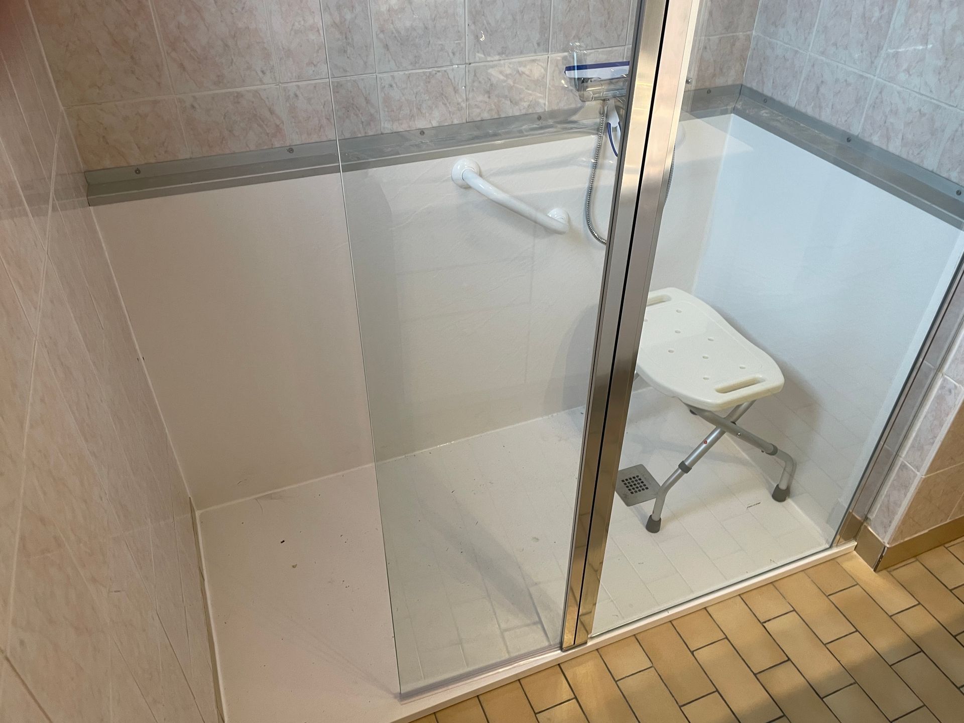 Douche à l'italienne pour PMR avec poignée de maintien et tabouret pour assise