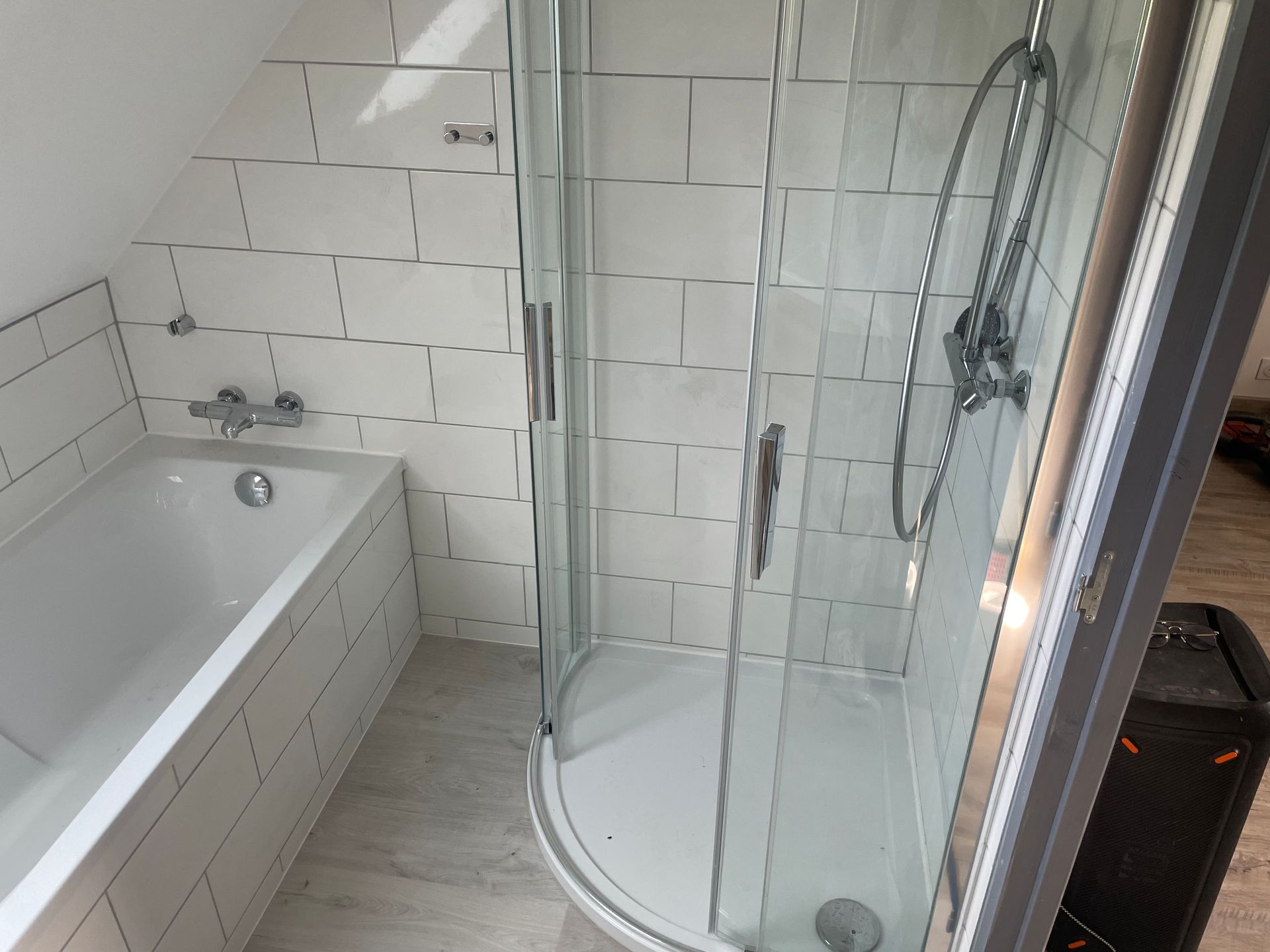 Même salle de bains avec murs carrelés avec baignoire et cabine de douche en angle