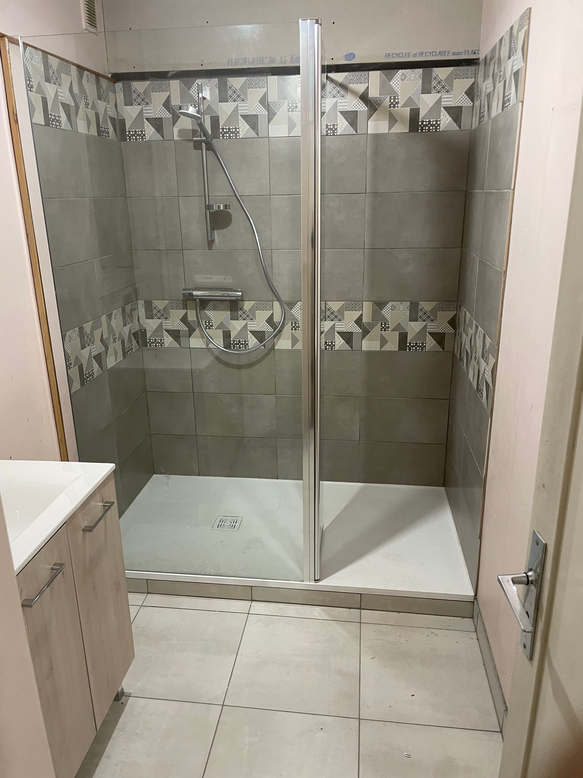 Cabine de douche avec porte vitrée munie d'une ouverture latérale