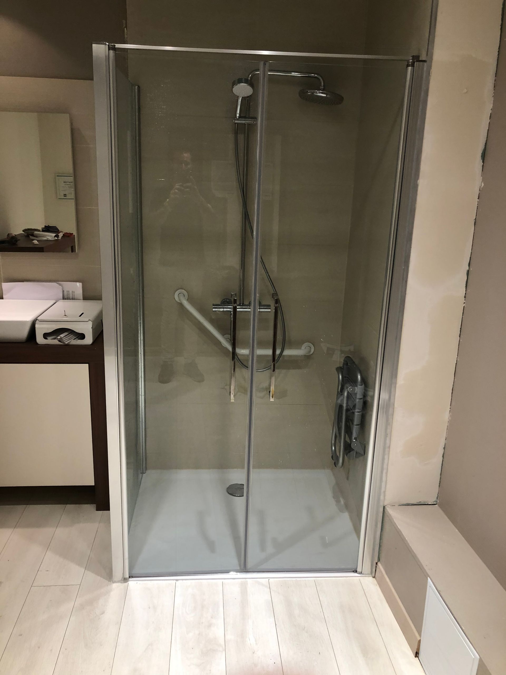 Cabine de douche PMR avec doubles portes vitrées munies de poignées