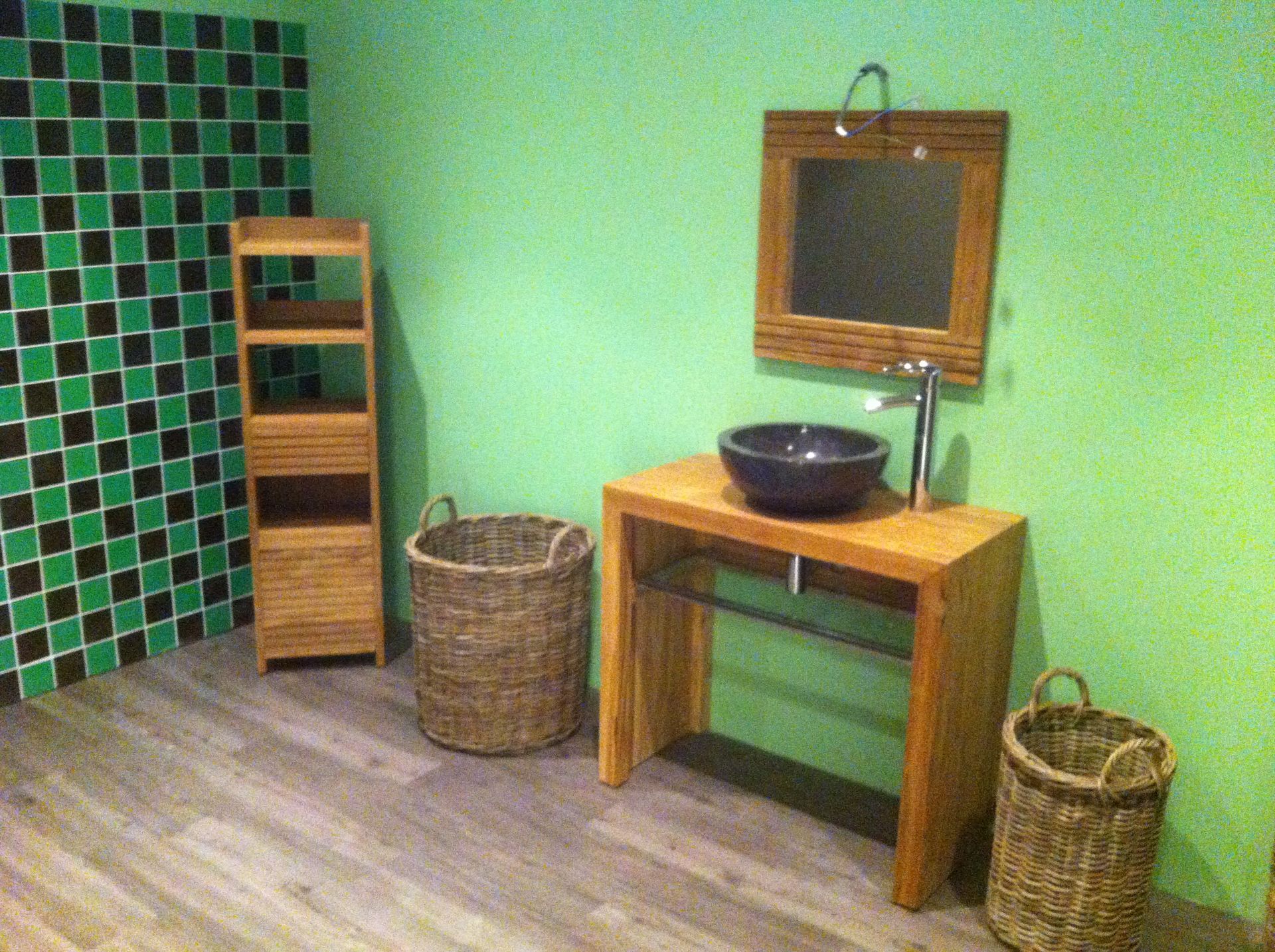 Installation d'une vasque sur un meuble en bois dans une salle de bains verte
