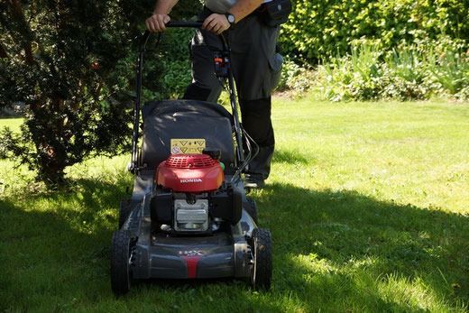 Eine Frau sitzt auf einer Couch und telefoniert mit einem Mobiltelefon.