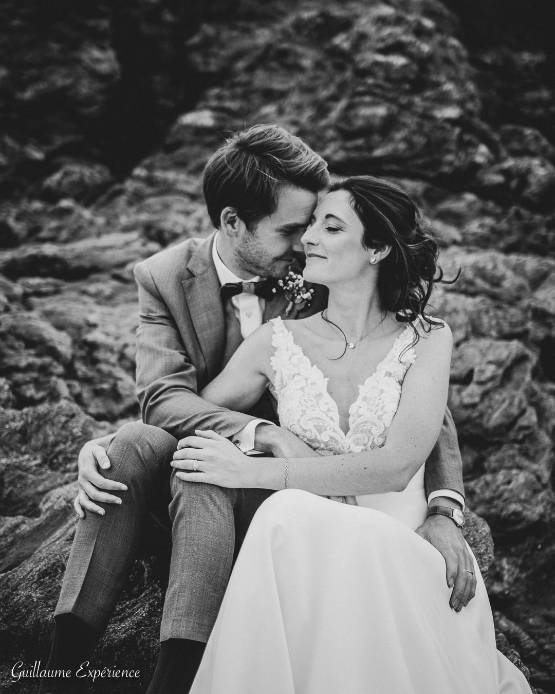 Le marié en costume crème verse du champagne à la mariée en robe à épaules dénudées en voiture.