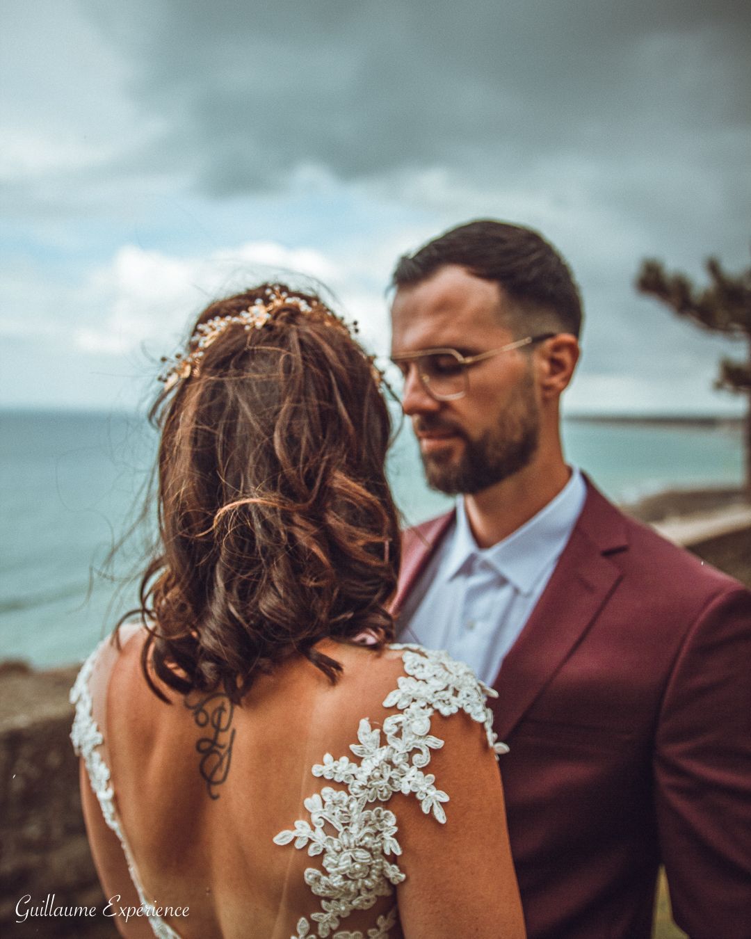 Les jeunes mariés s'embrassent et marchent vers une tente de fête entourée d'étincelles et de fumée.