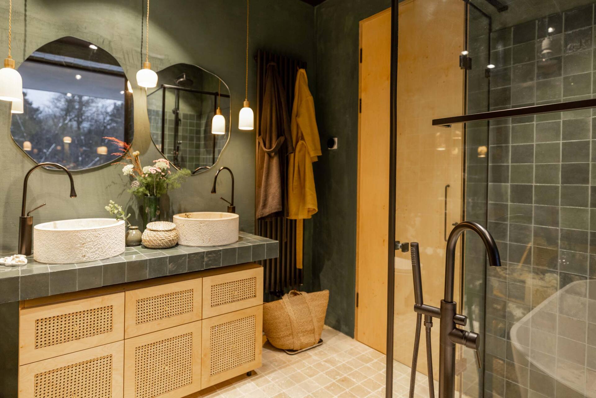 Intérieur de salle de bain aux tons verts avec vasques et sol en travertin