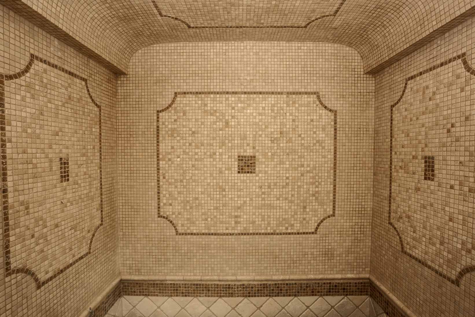Les murs d'une salle de bain en mosaïque de travertin dans les tons beiges