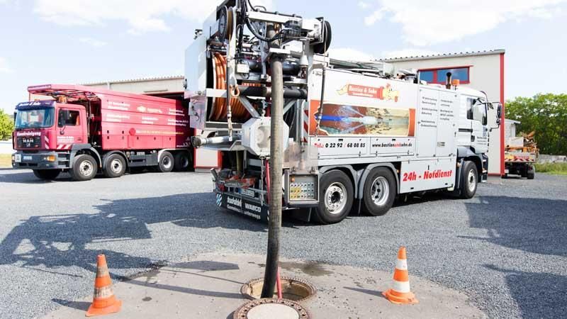 Ein Saugwagen steht vor einem Gebäude
