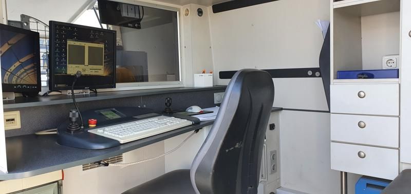 Ein Schreibtisch mit Stuhl und einem Computer darauf