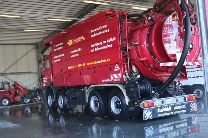 Ein großer roter Saugwagen steht in einer Garage
