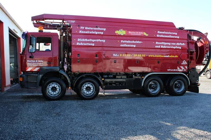 Ein roter LKW steht vor einer Garage