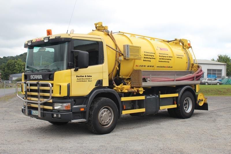 Ein gelber Saugwagen steht auf einem Kiesplatz