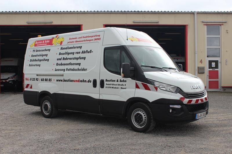 Ein weißer Lieferwagen steht vor einem Gebäude