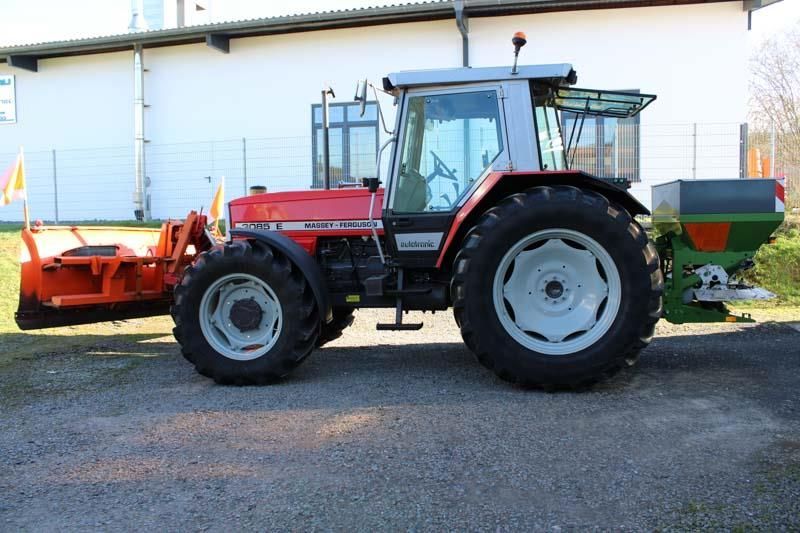 Ein roter Traktor steht vor einem weißen Gebäude