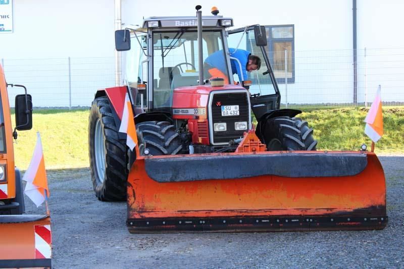 Ein roter Traktor mit einem daran befestigten Pflug
