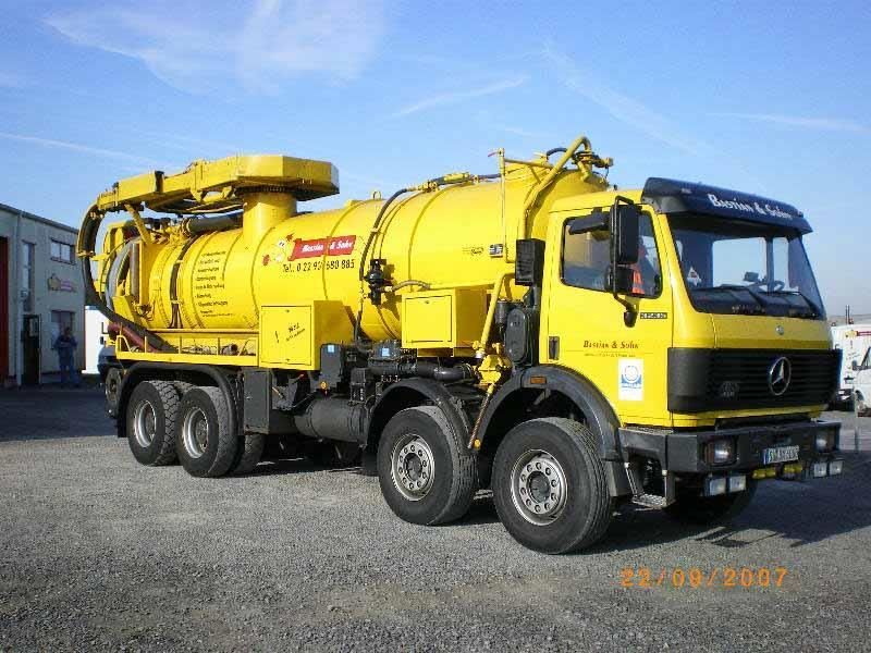 Ein gelber Mercedes-Truck steht auf einem Schotterplatz