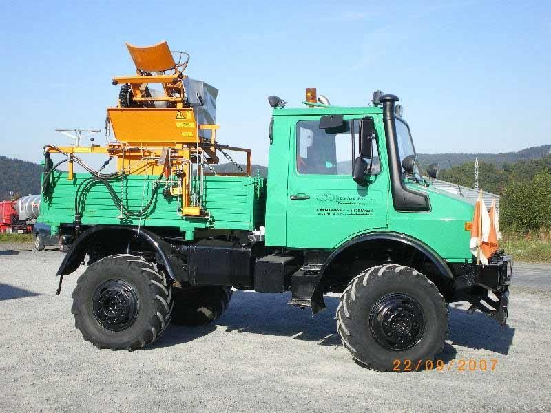 Ein grüner LKW steht auf einem Schotterplatz