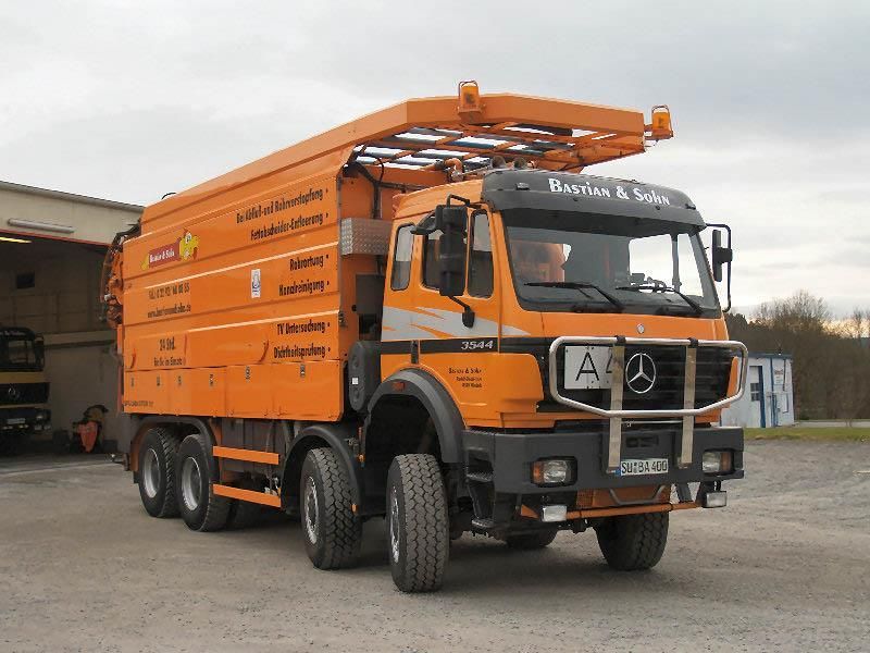 Ein orangefarbener Mercedes-Truck steht auf einem Parkplatz