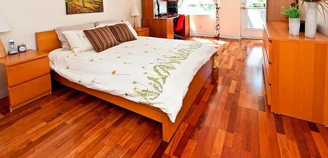 Un dormitorio con pisos de madera y una cama.
