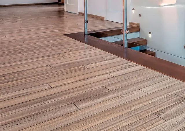 Un piso de madera con una escalera al fondo.