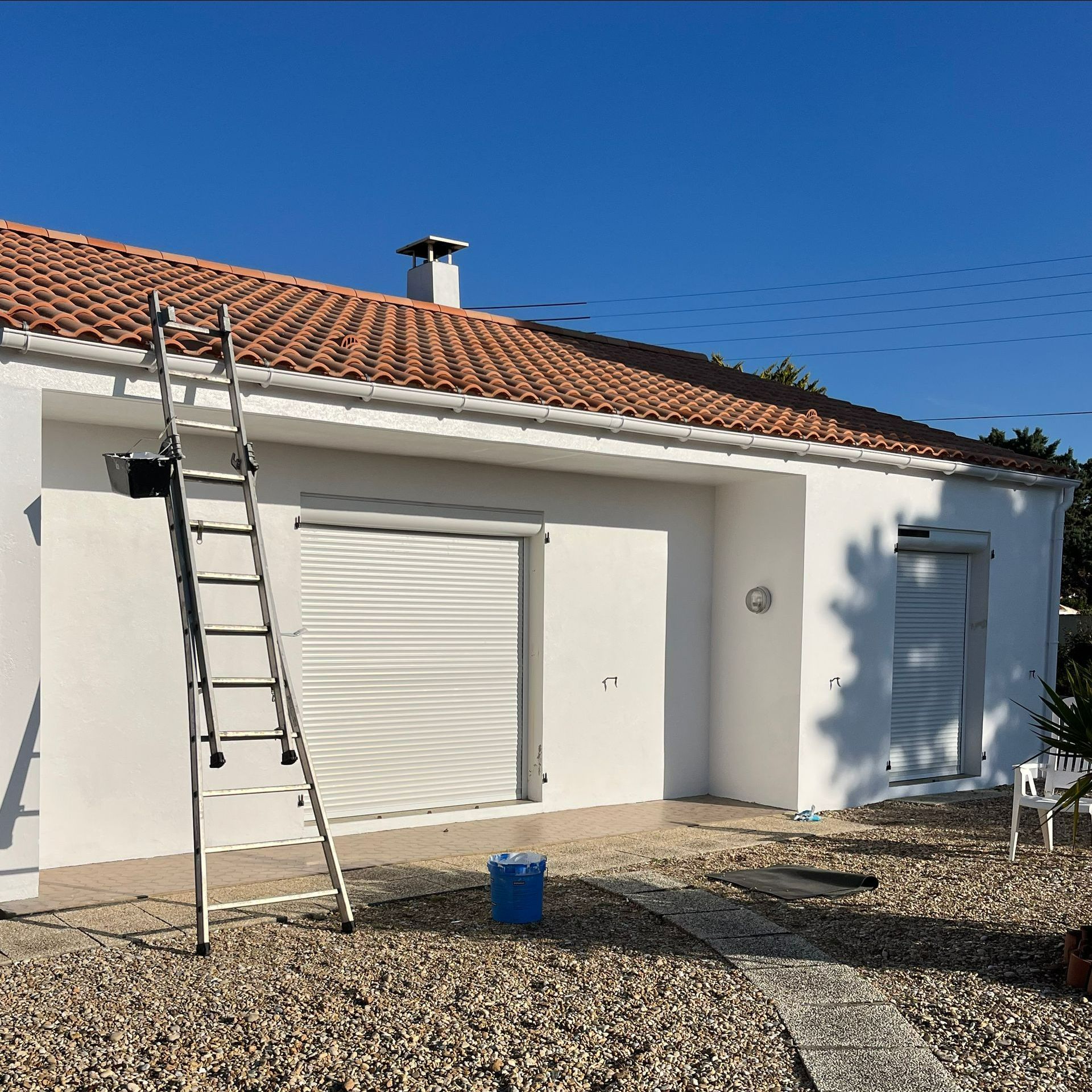 Façade de maison avec échelle et seau de peinture