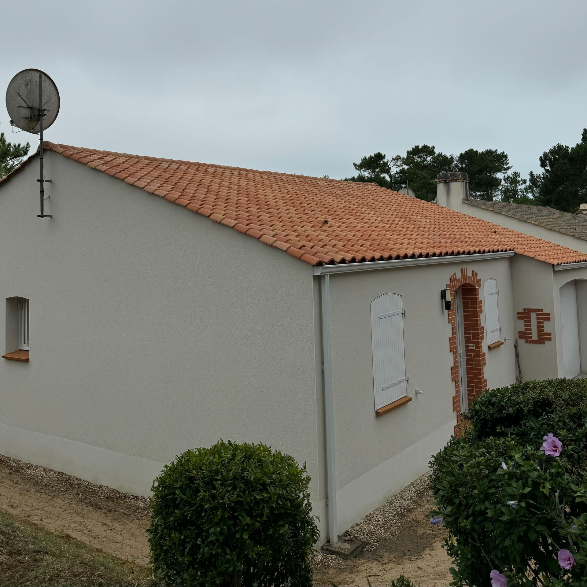 Maison vue de biais avec une toiture en tuile propre