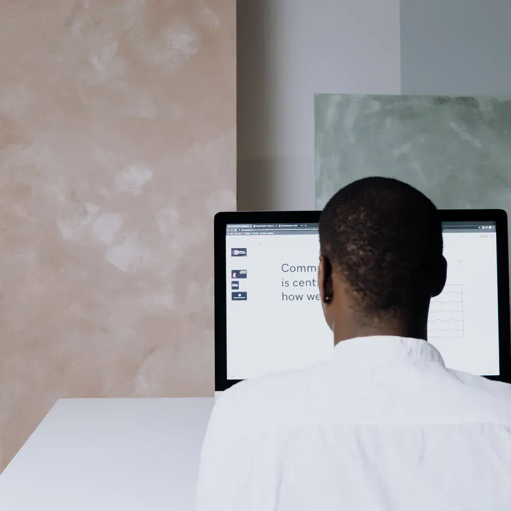 Un hombre está mirando una pantalla de computadora que dice