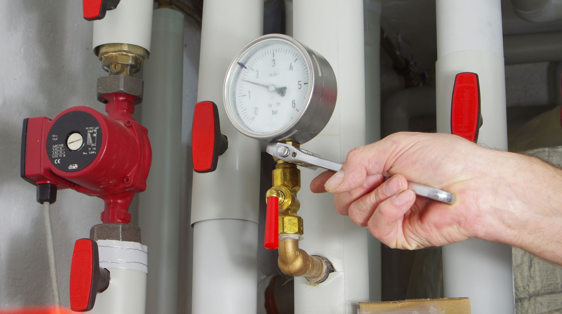 Main tenant une clé à molette serrant un écrou