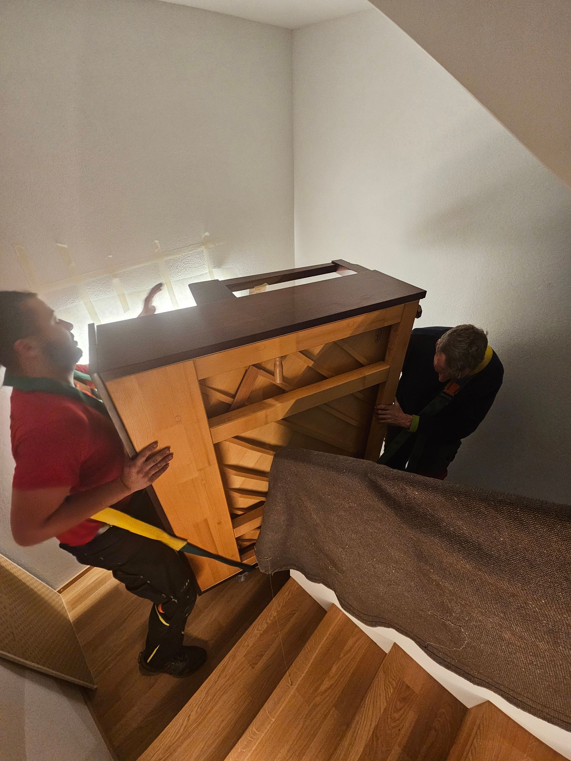 Moto fixée dans une benne de camion avec des sangles noires et une bâche bleue.