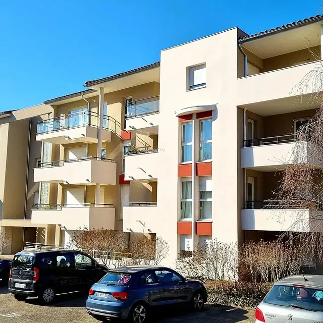 Façade d'immeuble, beige avec des touches de rouge.