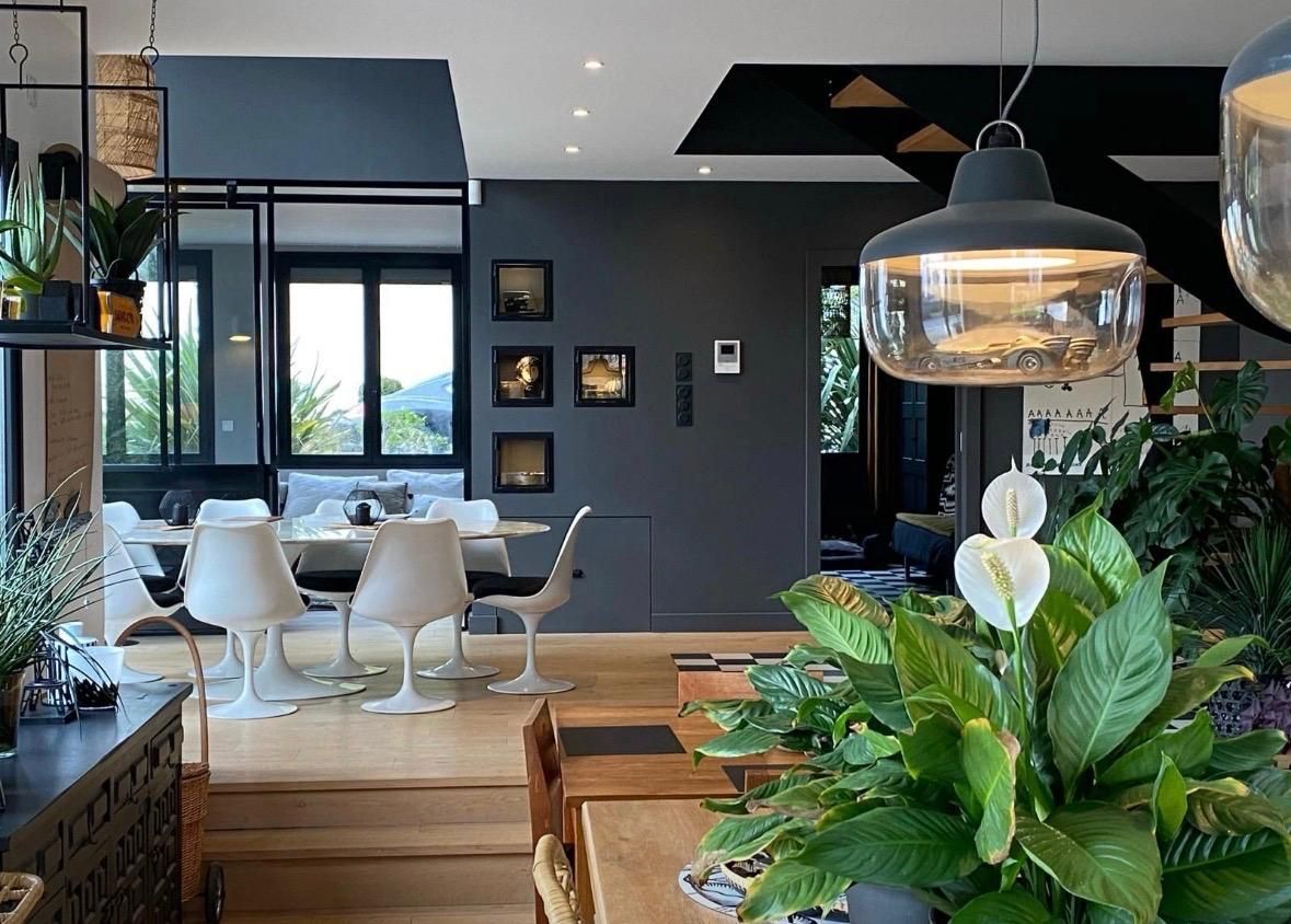 Escalier moderne noir et bois avec sol à carreaux, murs gris et porte fermée.