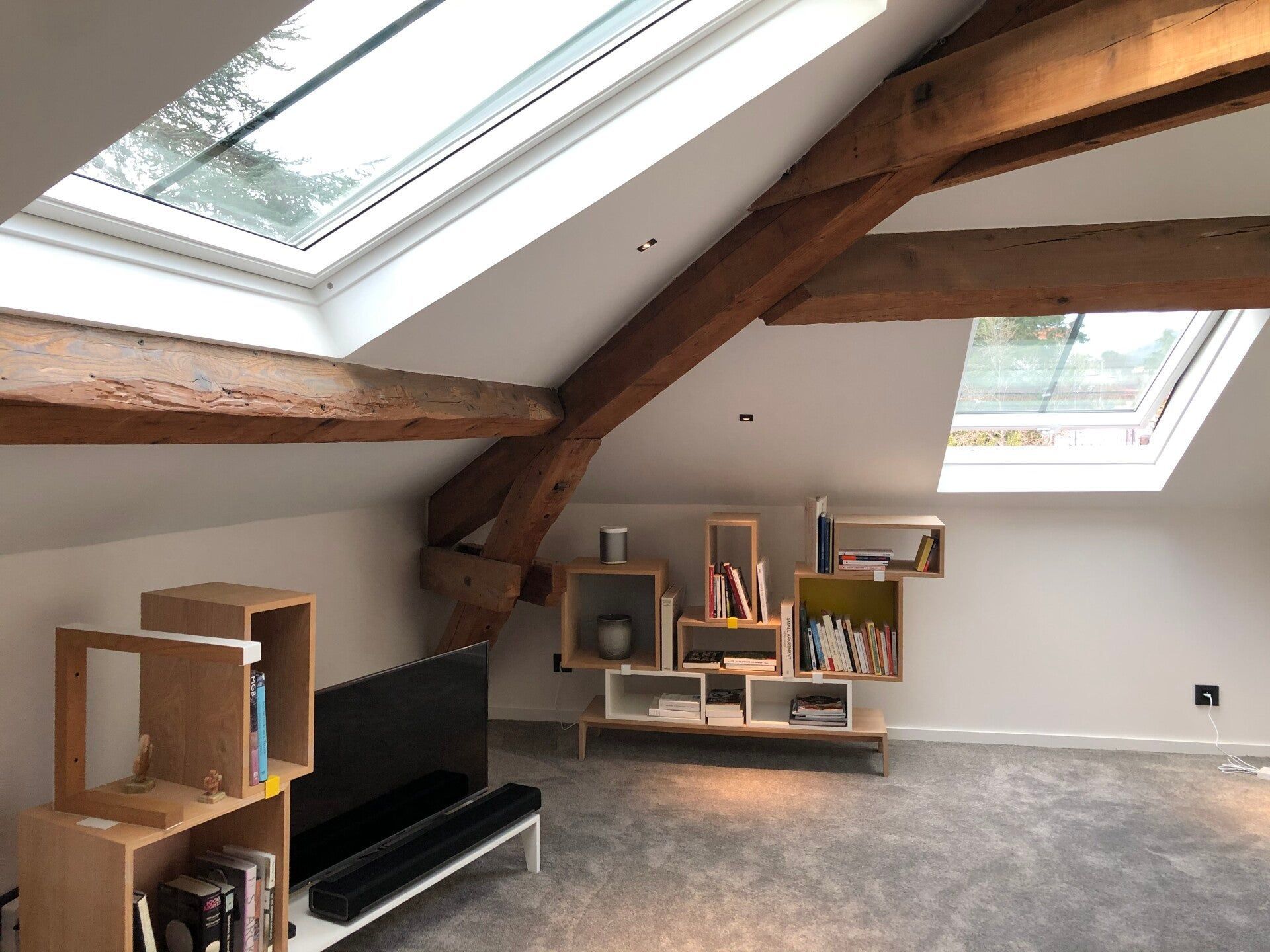 Poutre apparente à côté d'une fenêtre dans le toit dans les combles.