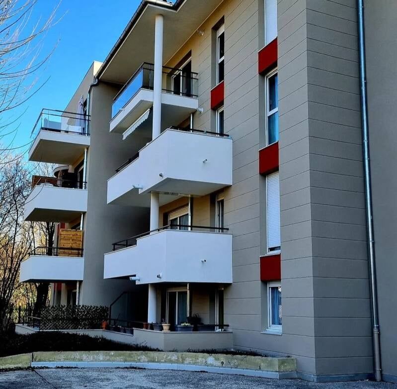 Immeuble d'appartements à plusieurs étages avec balcons blancs.