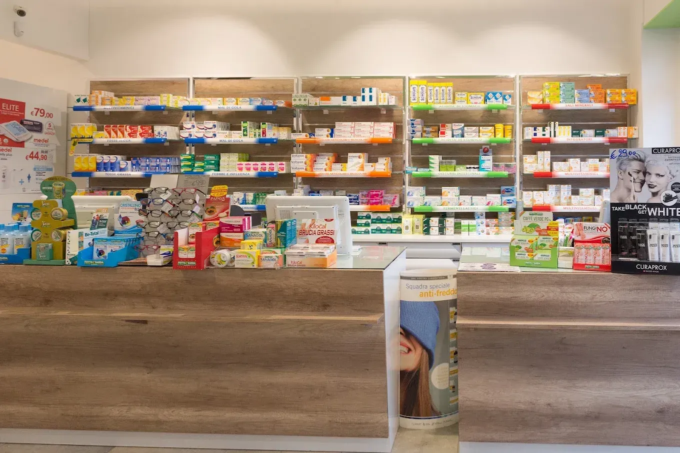 Bancone della farmacia Ragni e dietro con scaffali di prodotti