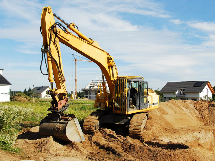 Tractopelle jaune au milieu de travaux de terrassement