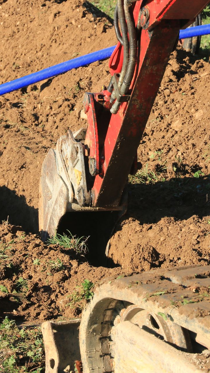 Création d'une tranchée avec une tractopelle rouge